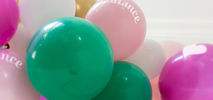 Viele große Luftballons in mehreren Farben sind mit Logos bedruckt.